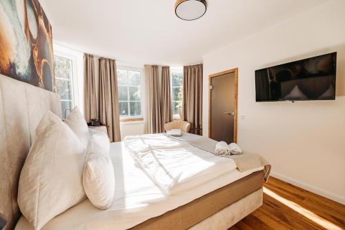 a bedroom with a large white bed with white pillows at Schlosshotel Brilon-Wald in Brilon-Wald