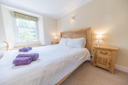 a bedroom with a large white bed and a window at 2 Dixon Ground Coniston in Coniston