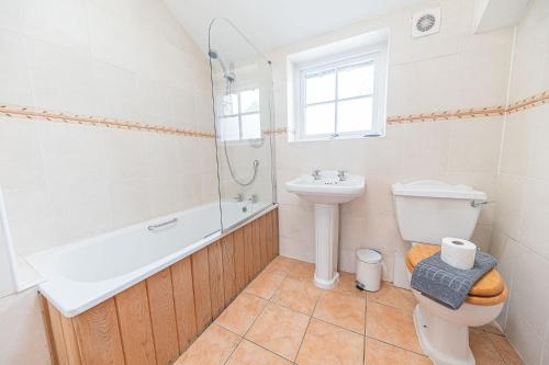 a bathroom with a toilet and a sink and a bath tub at 2 Dixon Ground Coniston in Coniston