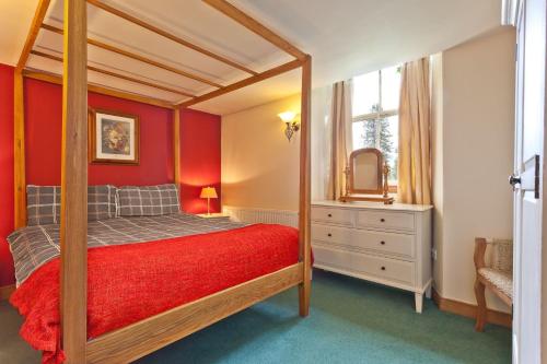 a bedroom with a canopy bed and a mirror at 4 Dixon Ground Coniston in Coniston