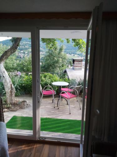 a sliding glass door leading to a patio with a table and chairs at Apartman MIA in Travnik