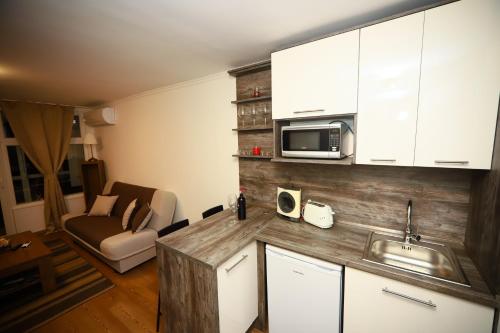 a kitchen with a sink and a microwave at Mamma Mia Apartmanok in Harkány