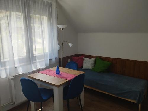 a room with a bed and a table and chairs at Börzsöny Vendégház in Zebegény