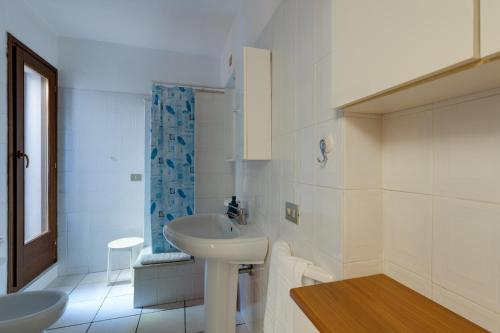 a white bathroom with two sinks and a shower at Villa del Maestro in Narbolia