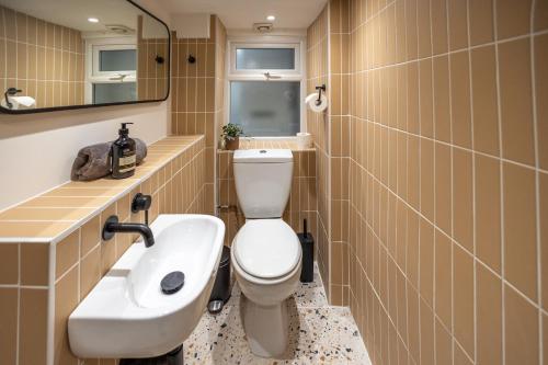 a bathroom with a toilet and a sink and a mirror at Bright & beautiful 4 bedroom house with sea views in Portland
