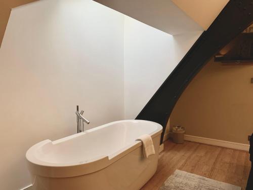 eine weiße Badewanne in einem Zimmer mit Dachgeschoss in der Unterkunft Quebecs Luxury Apartments in Leeds