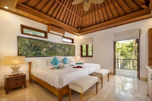 - une chambre avec un grand lit et 2 chaises dans l'établissement The Allure Ubud Villas, à Ubud