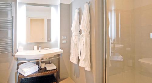 a white bathroom with a sink and a shower at Adamas Luxury Suite in Rome