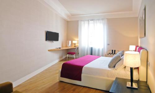 a hotel room with a bed and a desk at Adamas Luxury Suite in Rome