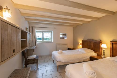 a hotel room with two beds and a window at Gite Le Foineau - Maison avec Piscine in Bresse-sur-Grosne