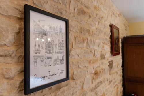 un cuadro colgado en una pared de piedra en Gite Le Foineau - Maison avec Piscine, en Bresse-sur-Grosne