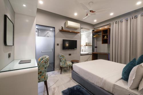 a bedroom with a bed and a desk and a tv at Moustache Hostel, Jaipur in Jaipur