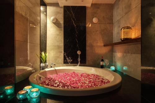 a bathroom with a large bath tub filled with pink petals at Moustache Hostel, Jaipur in Jaipur