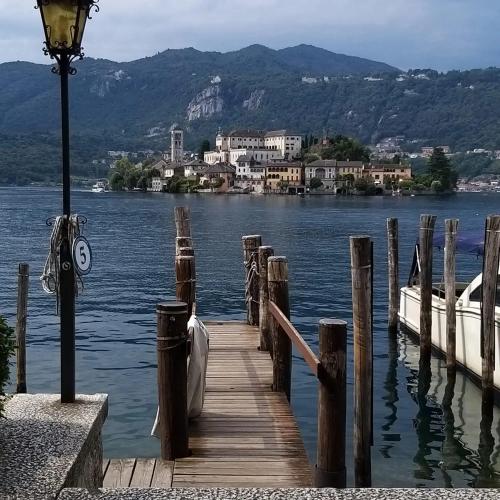a dock on a lake with a boat on the water at Marianna casa vacanza in Azzate