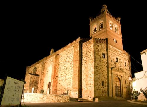 a large building with a clock tower at night at Hotel Rural El Arriero in La Zarza