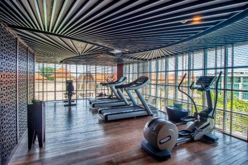 a gym with treadmills and elliptical machines at The Sakala Resort Bali All Suites in Nusa Dua