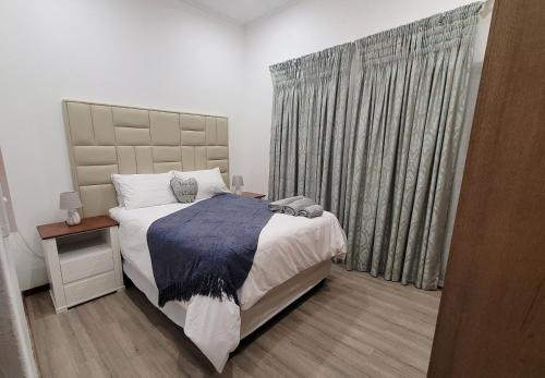 a bedroom with a large bed and a window at Sebs Chalet in Hartbeespoort