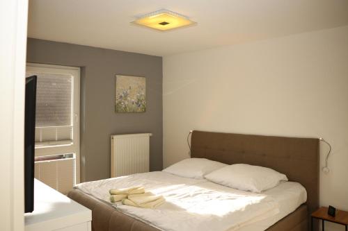 a small bedroom with a bed with white sheets at Ferienwohnungen Buchenweg in Ostseebad Sellin