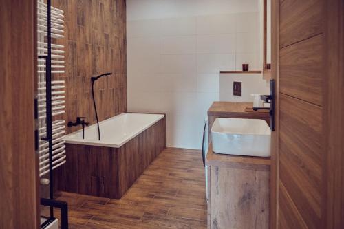 La salle de bains est pourvue d'une baignoire et d'un lavabo. dans l'établissement WieliczkaHome 1st floor + garden + parking, à Wieliczka