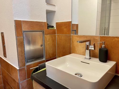 a bathroom with a white sink and a mirror at Moderne Ferienwohnung in Bad Waldsee
