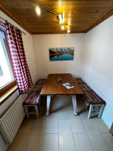 a dining room with a wooden table and a bench at Brenners Dorfstube in Fieberbrunn
