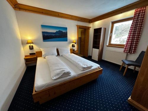 a bedroom with a large bed in a room at Brenners Dorfstube in Fieberbrunn