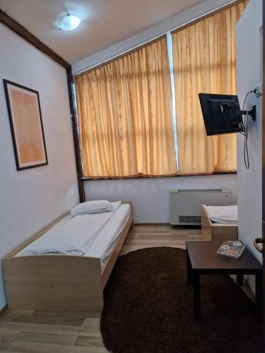 a small bedroom with a bed and a window at Pensiunea Carpe Diem in Râmnicu Vâlcea