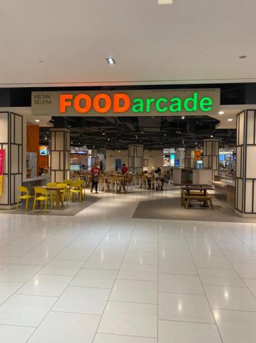 a food agency sign in a mall with tables and chairs at Damen Suite Sunway Subang by DW in Subang Jaya