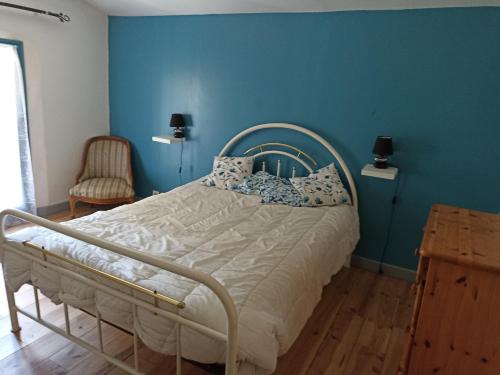 1 dormitorio con 1 cama con pared azul en la ferme des pres, 