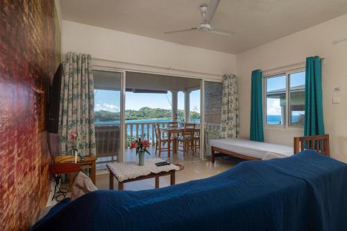 a bedroom with a bed and a view of the ocean at TOP VIEW RETREAT SELFCATERING in Anse a La Mouche