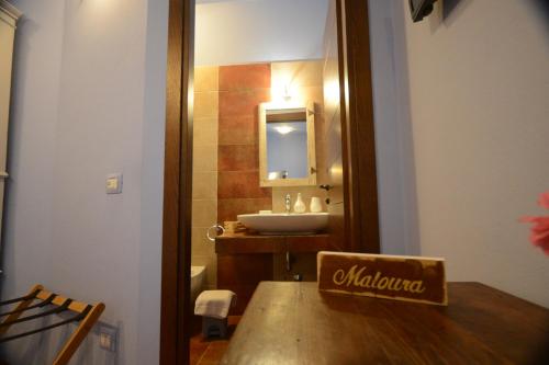 uma casa de banho com uma mesa, um lavatório e um espelho. em Agriturismo Maloura em Savignano sul Rubicone