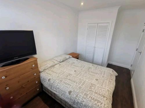 um quarto com uma cama e uma televisão numa cómoda em Spacious 2BDR Apartment, WIFI+ Great TV em Romford