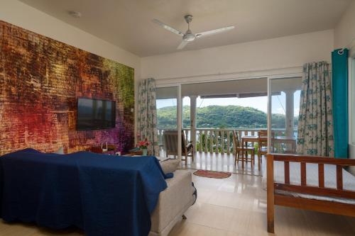 a living room with a couch and a tv on a wall at TOP VIEW RETREAT SELFCATERING in Anse a La Mouche