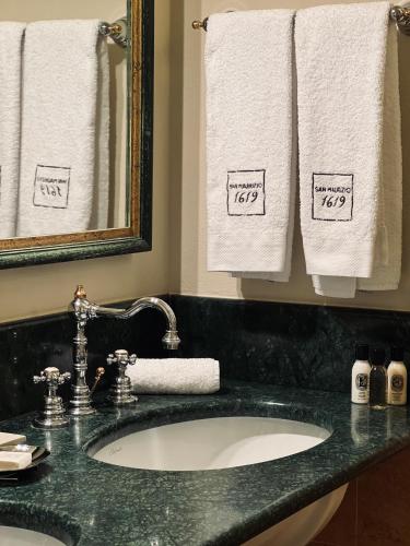 a bathroom with a sink and a mirror and towels at Relais San Maurizio in Santo Stefano Belbo