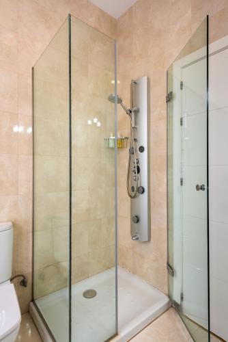 a shower with a glass door in a bathroom at SevilleBnB Group- Cathedral Apartment, 1st Floor in Seville