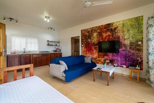 a living room with a blue couch and a tv at TOP VIEW RETREAT SELFCATERING in Anse a La Mouche