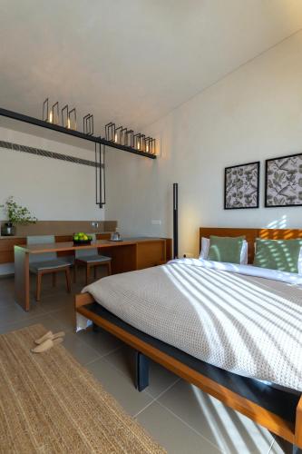 a bedroom with a large bed and a desk at Life At REPOSE- Lake Villas Resort & Club in Chor Warodra