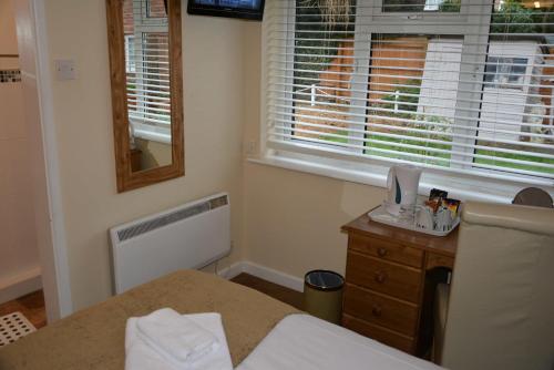 a bedroom with a bed and a window and a sink at Ashlea Guest House in Banbury
