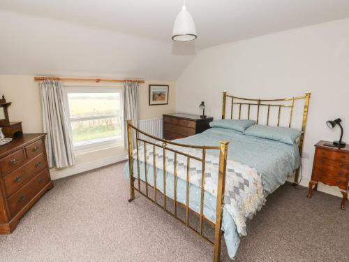 a bedroom with a bed and a dresser and a window at Nash Lodge in Pembroke Dock