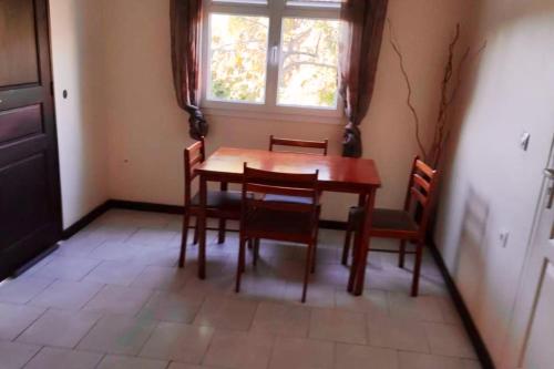 a dining room with a table and chairs and a window at Belle villa avec piscine privée à Le Carbet in Le Carbet