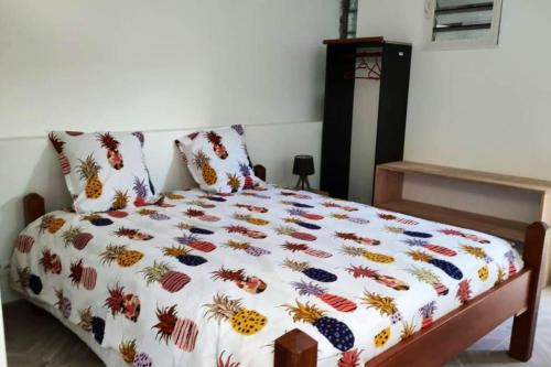 a bedroom with a bed with a colorful comforter at Belle villa avec piscine privée à Le Carbet in Le Carbet
