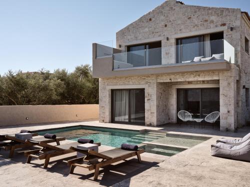 a house with a swimming pool in front of it at Seaside Luxury LaTerre, Zante Zen By ThinkVilla in Psarou