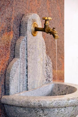 a fountain with a water faucet on top of it at Landhaus Aggenstein in Haldensee