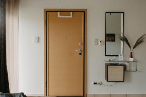 a wooden door in a room with a mirror at DimSim Home-Σπίτι με όνομα in Tríkala