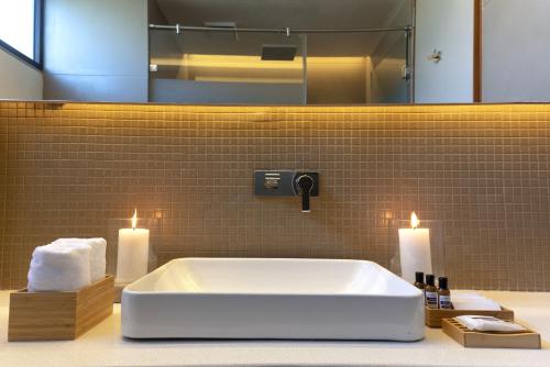 uma casa de banho com uma banheira com 2 velas e um espelho. em Life At REPOSE- Lake Villas Resort & Club em Chor Warodra