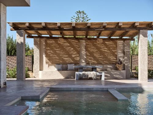 a pergola with a table and a pool at Seaside Luxury LaTerre, Zante Zen By ThinkVilla in Psarou