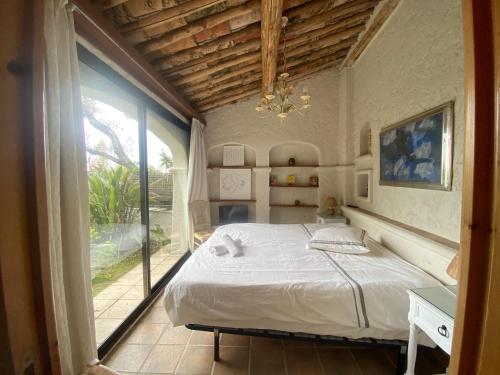 une chambre avec un lit et une grande fenêtre dans l'établissement Somptuous exotic villa in Cannes, à Cannes