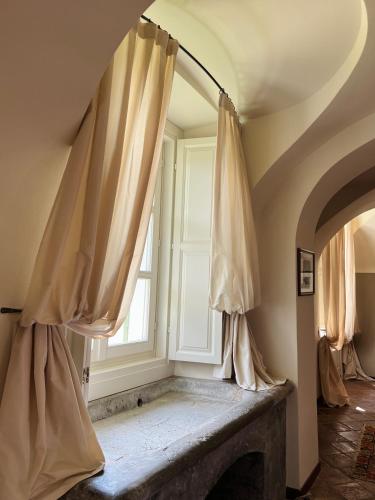 a room with a window and a stone fireplace at Relais San Maurizio in Santo Stefano Belbo