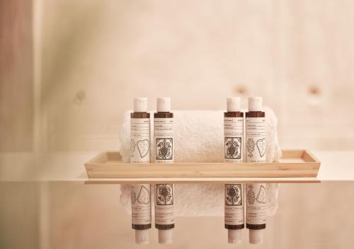 a shelf with four bottles of toilet paper and towels at Cute n Comfort Luxury Condo in Kolonaki in Athens