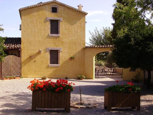 a large yellow building with flowers in front of it at Azienda Agrituristica Le Puzelle in Santa Severina